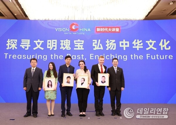 Liu Huiyan (far left), head of the publicity department of the CPC Liaoning Provincial Committee, and Qu Yingpu (far right), publisher and editor-in-chief of China Daily, pose for photos with speakers after presenting them keepsakes during the Vision China event in Jinzhou, Liaoning province, on Sunday. [Photo by Feng Yongbin/China Daily]