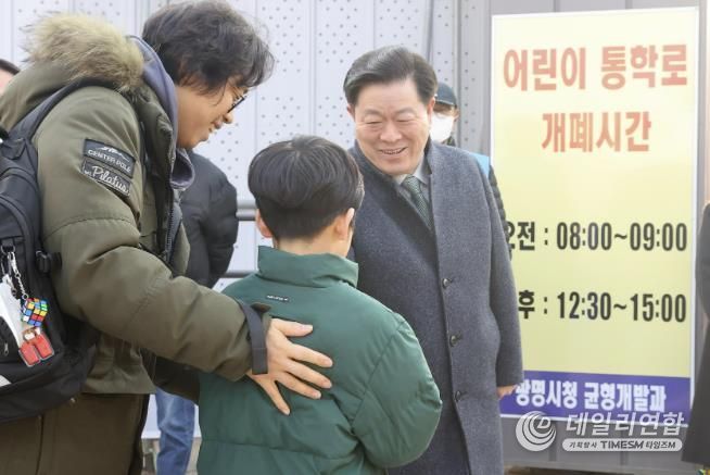 박승원 광명시장이 지난 3월 광명초등학교 광이로 임시 통학로를 점검하러 나서 등교하는 학생과 인사를 나누고 있다.