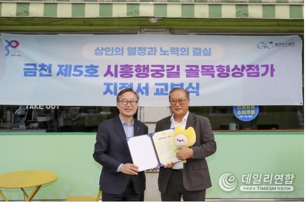 유성훈 금천구청장(왼쪽)과 김명식 상인회장이 골목형상점가 지정서 교부식을 진행하고 기념촬영을 하고 있다