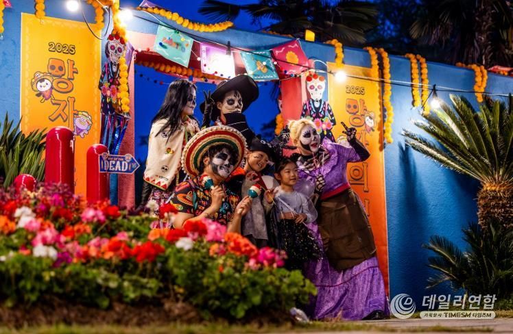 지난 25일 순천만국가정원에서 열린 ‘멕시코 망자의 정원 축제’에서 코스프레 복장을 한 배우들과 함께 사진을 찍는 아이들.