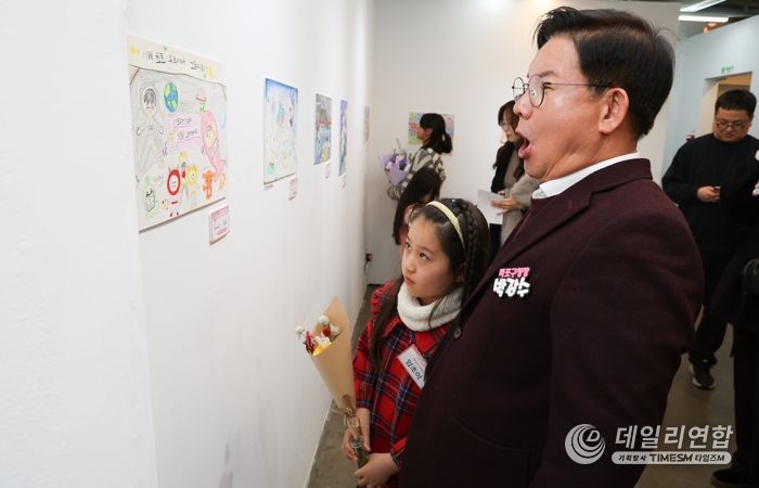 박강수 마포구청장이 수상 어린이와 함께 전시된 그림을 살펴보고 있다.