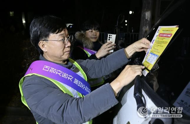 이민근 안산시장이 20일 새벽시간, 단원구 와동 일대에 불법 밤샘주차된 대형차랑에 계도문을 부착하고 있다.