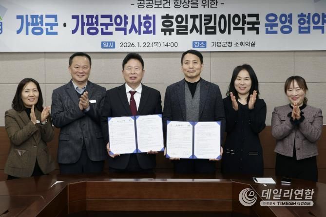 서태원 가평군수(사진 왼쪽에서 세번째)와 안병현 가평군약사회 회장(〃 네번째) 등이 22일 휴일지킴이약국 운영 협약식 후 협약서를 보이며 기념촬영을 하고 있다.